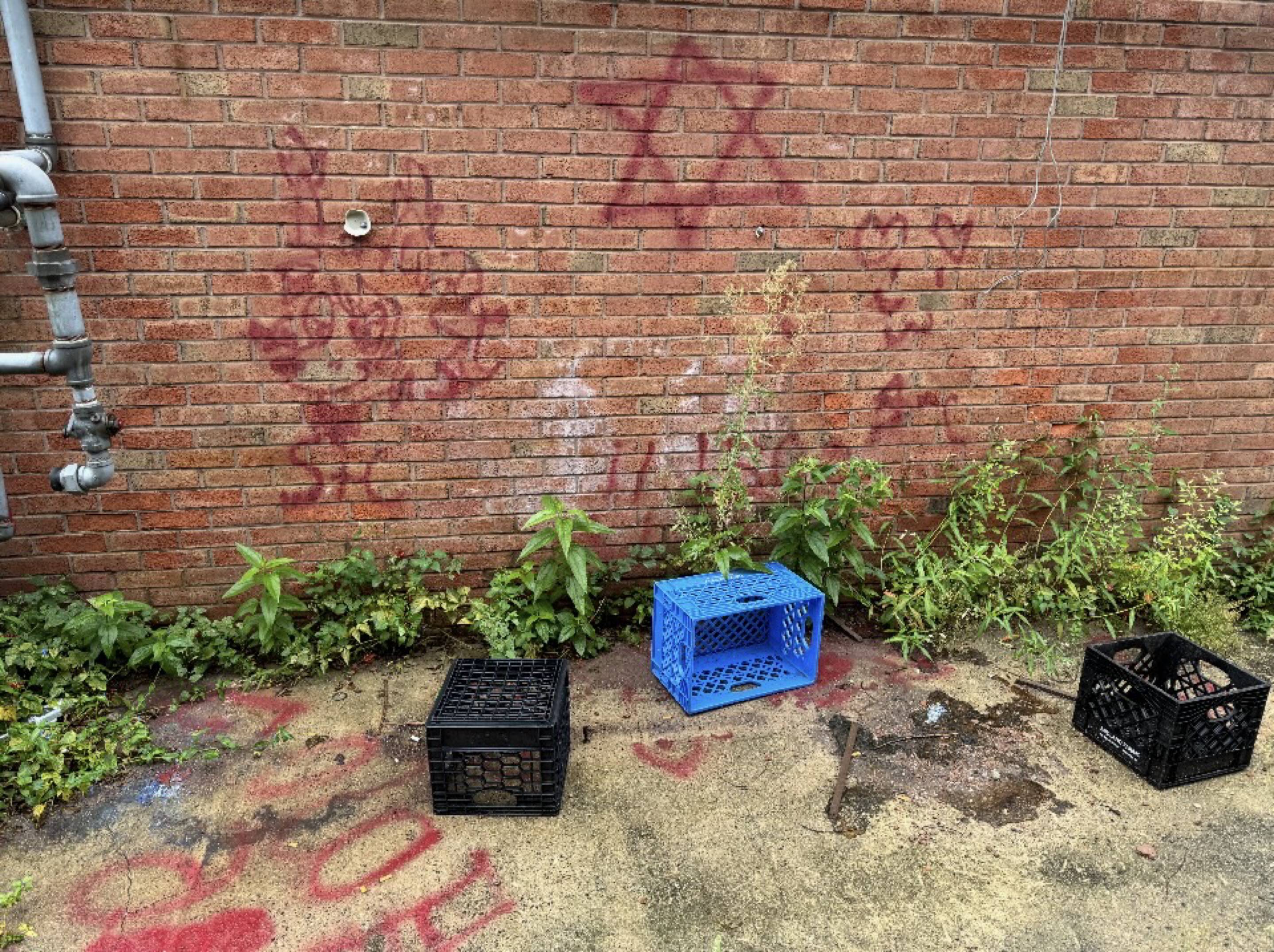 Graffiti painted across a brick wall and pavement.